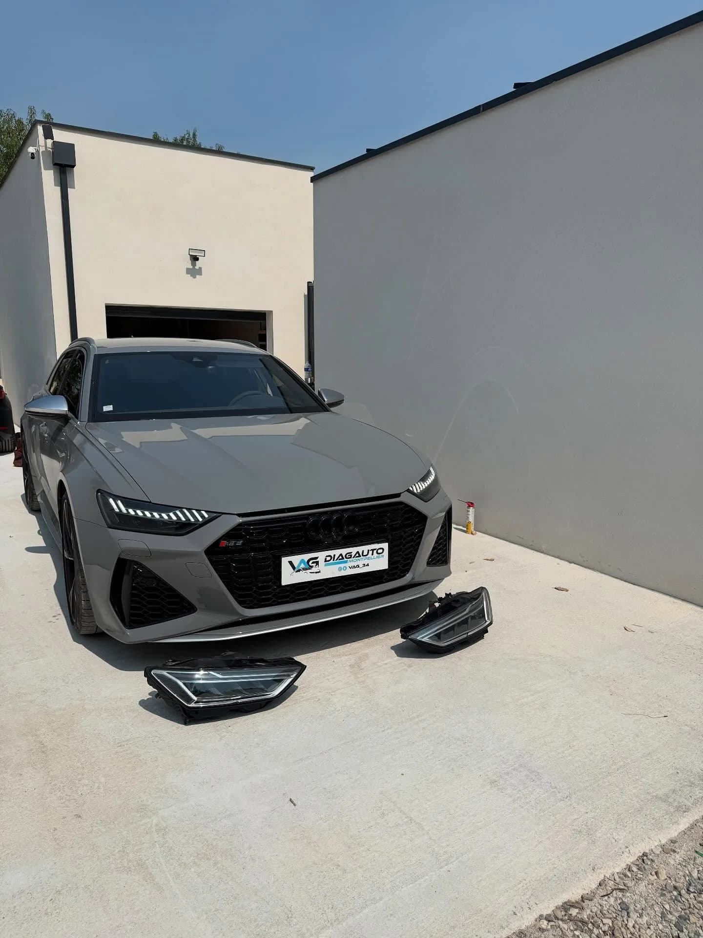 Audi RS6 C8 grise devant l’atelier VAG34, phares Matrix laser déposés au sol avant montage