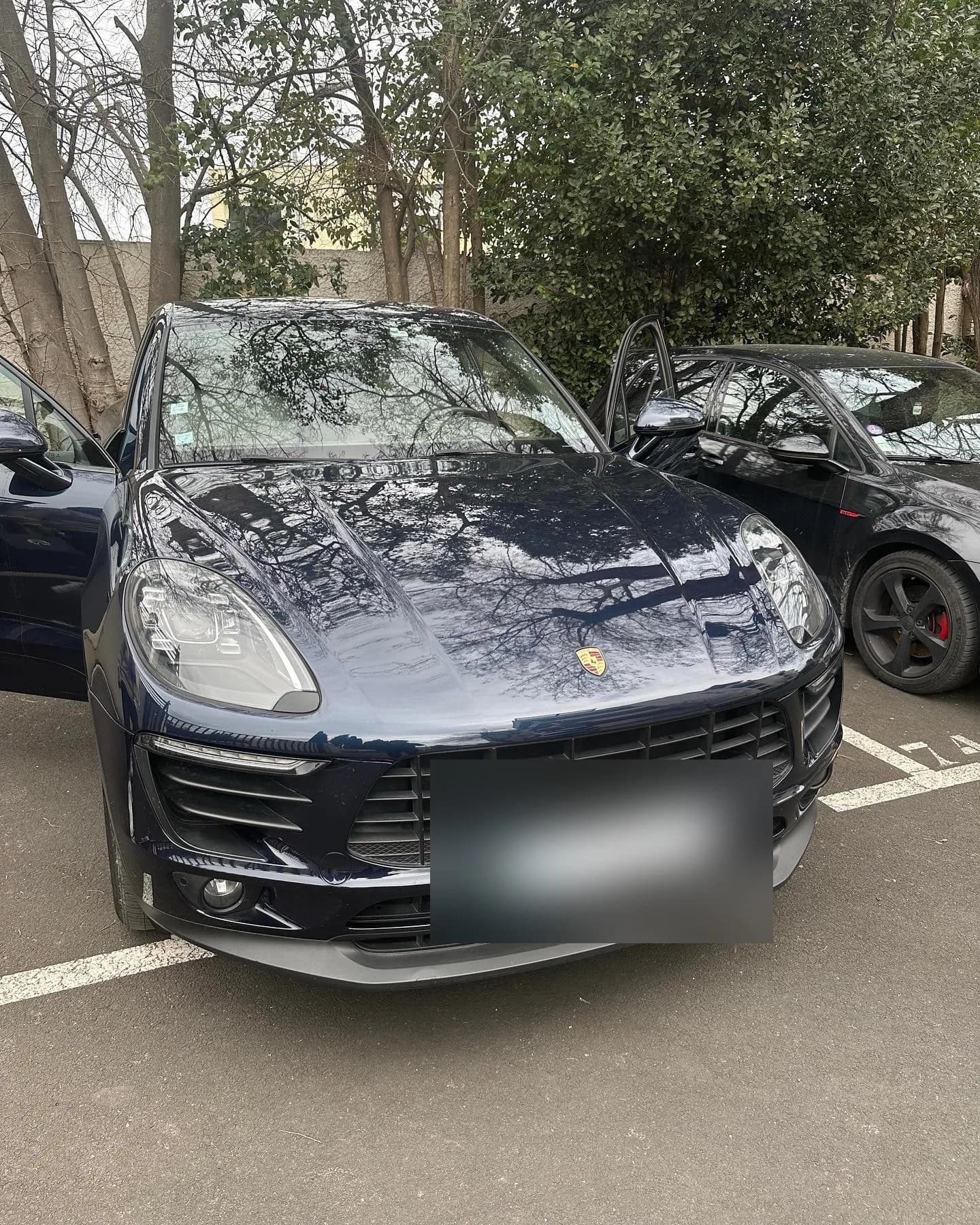 Porsche Macan bleu nuit stationné devant l’atelier avant activation d’Apple CarPlay